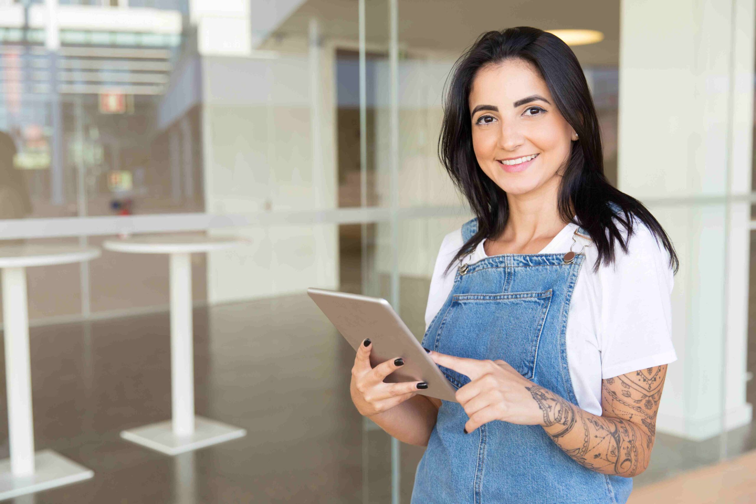 Mulher empreendedora segurando um tablet em frente a sua loja